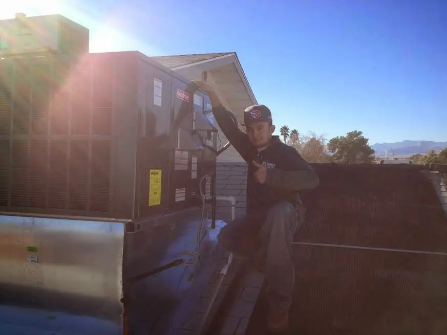 HVAC technician performing Heat Pump Repair on a rooftop unit in Alondra Park